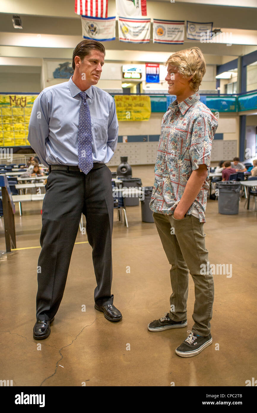 Un directeur de l'école parle avec l'un de ses élèves dans le bâtiment de l'école atrium dans Dana Point, CA. Banque D'Images