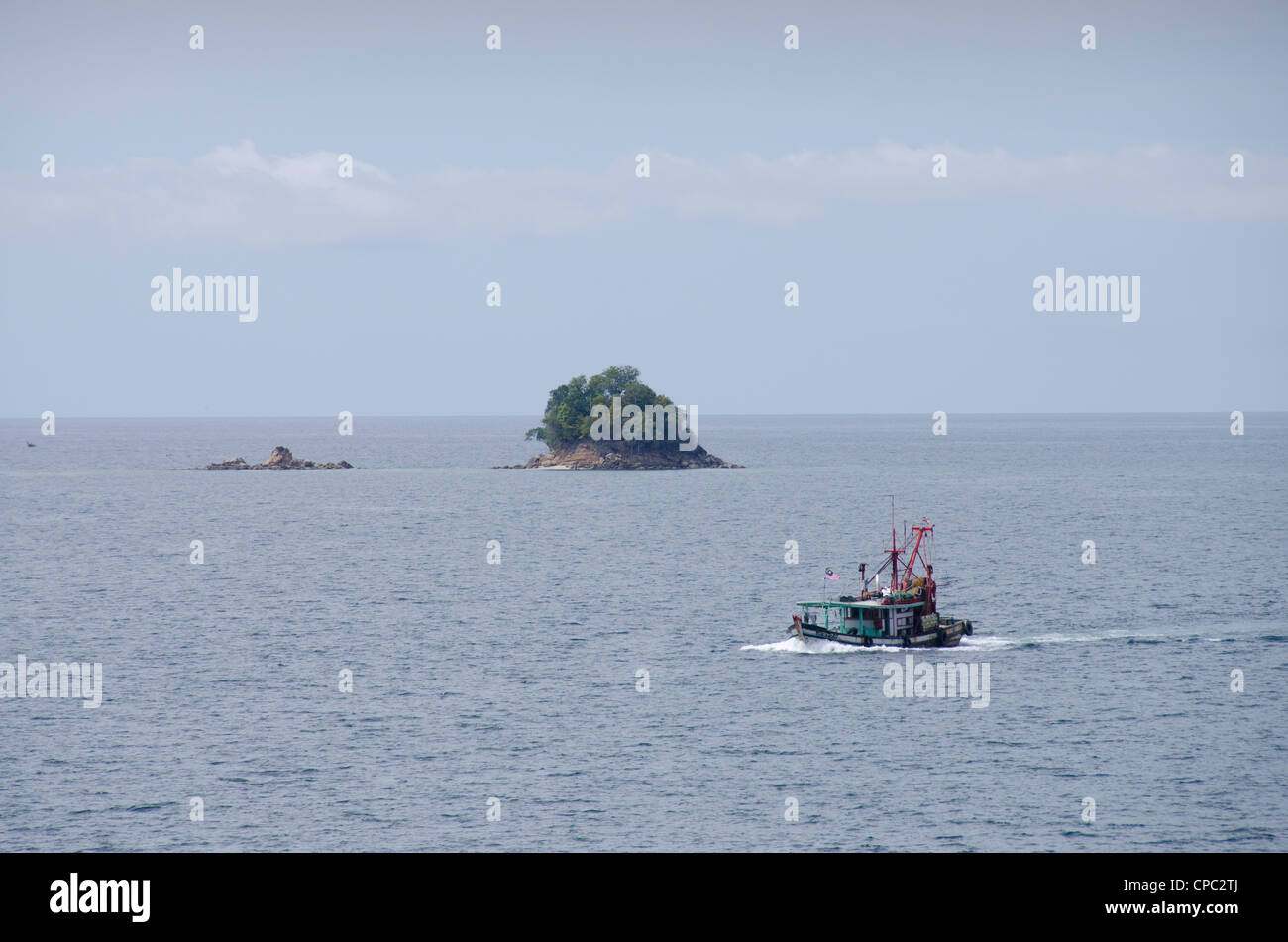 La Malaisie, l'île de Bornéo, de l'état de Sabah, Kota Kinabalu. bateau de pêche traditionnel orang en face de petite île. Banque D'Images