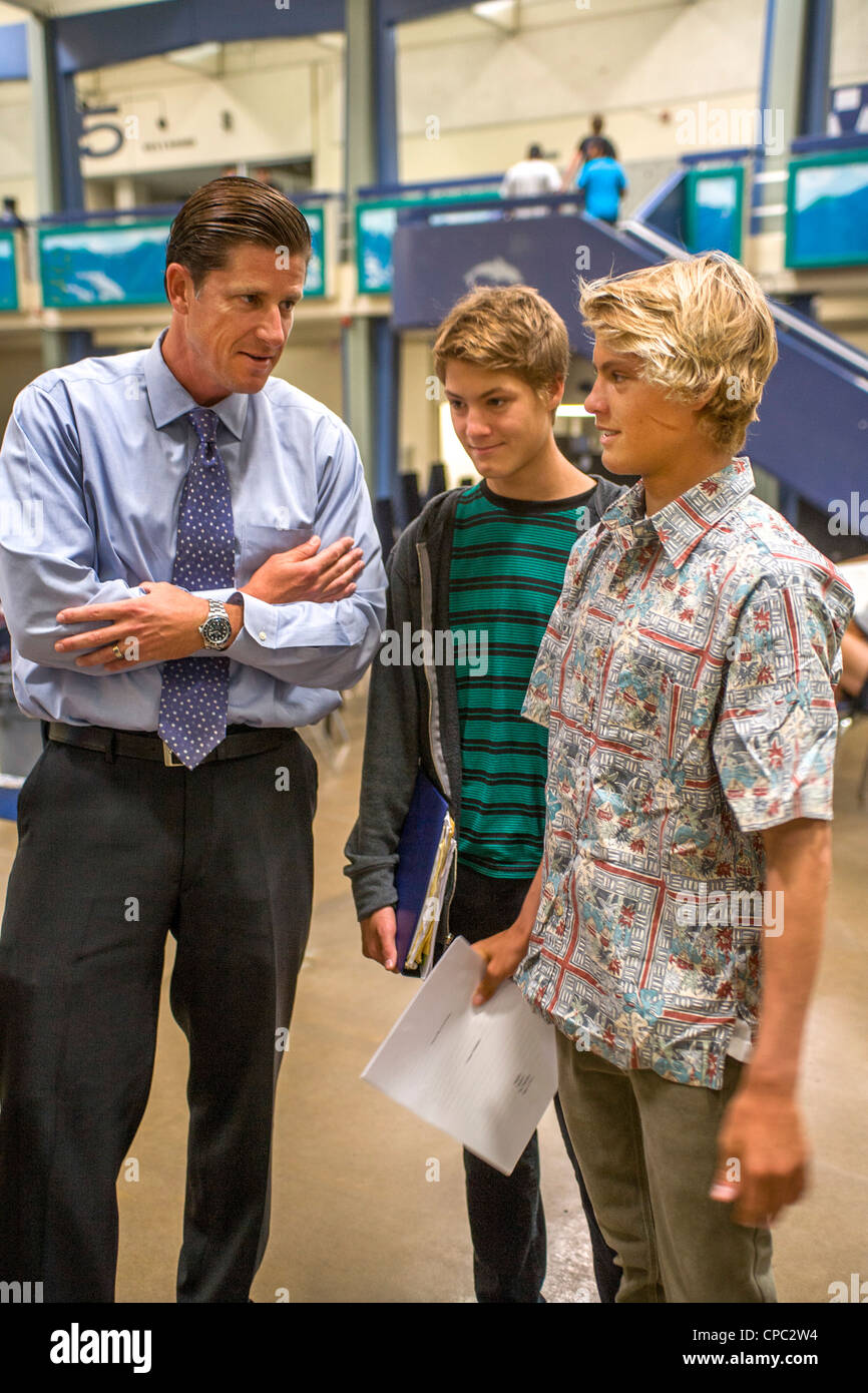 Un directeur de l'école parle avec deux de ses étudiants dans le bâtiment de l'école atrium dans Dana Point, CA. Banque D'Images