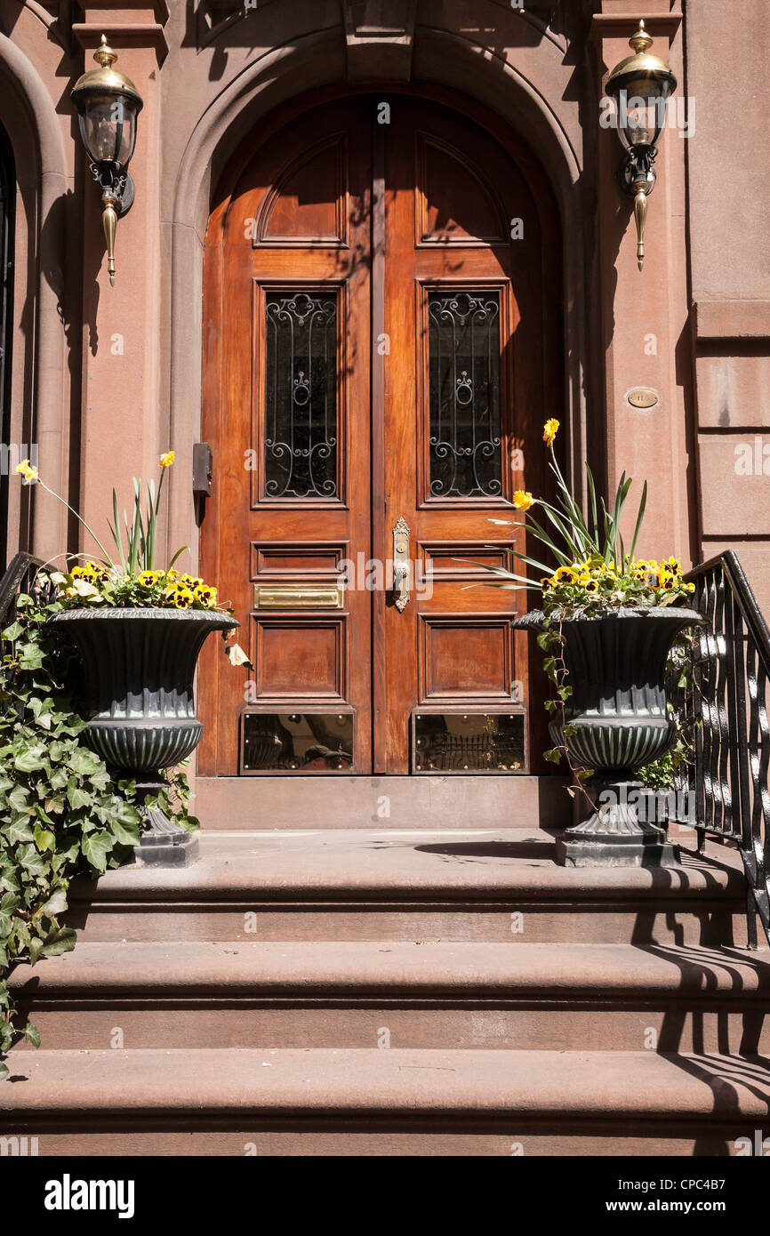 Brownstone ornementé entrée avec porte en bois sculpté et de pierre jardinières, NYC Banque D'Images