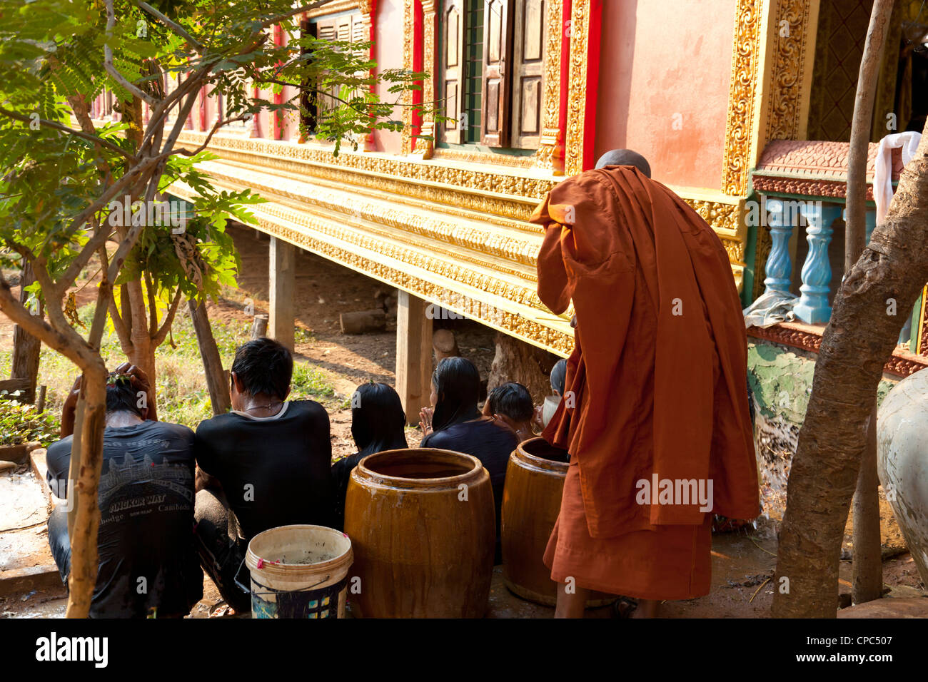 Cérémonie de bénédiction du nouvel an traditionnel. Un moine est pulvériser de l'eau prises à partir d'une urne sur la tête des enfants, au Cambodge. Banque D'Images