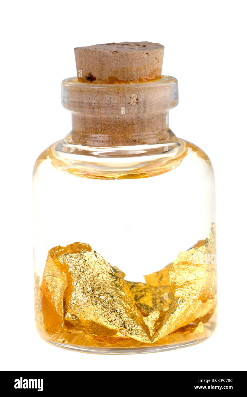 Paillettes d'or dans un liquide dans une bouteille Banque D'Images