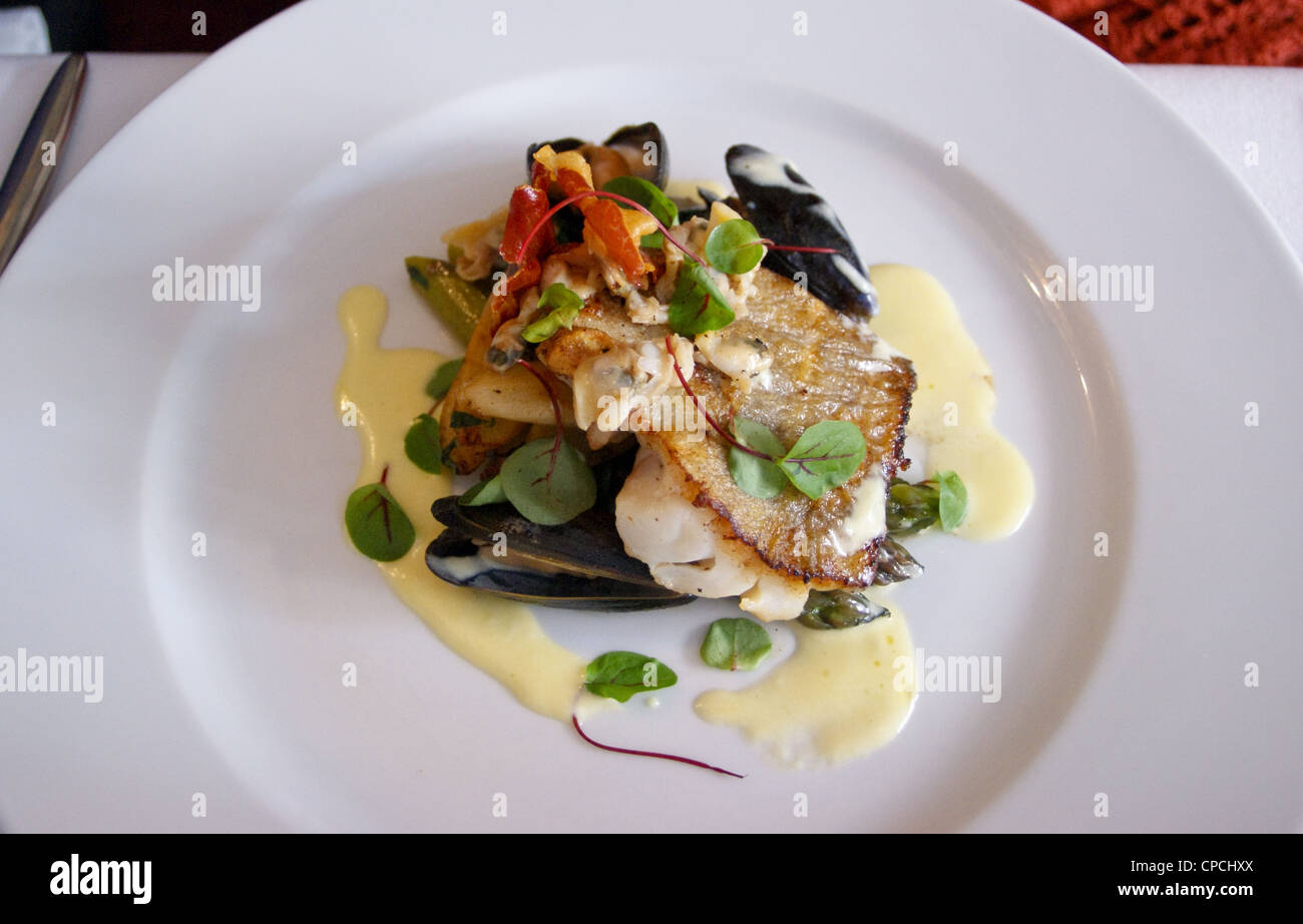 Le démarreur de coques, de moules et de la morue grillée avec bébé chard et sauce à la crème aigre, à Topes restaurant, Rochester, Kent, Angleterre Banque D'Images