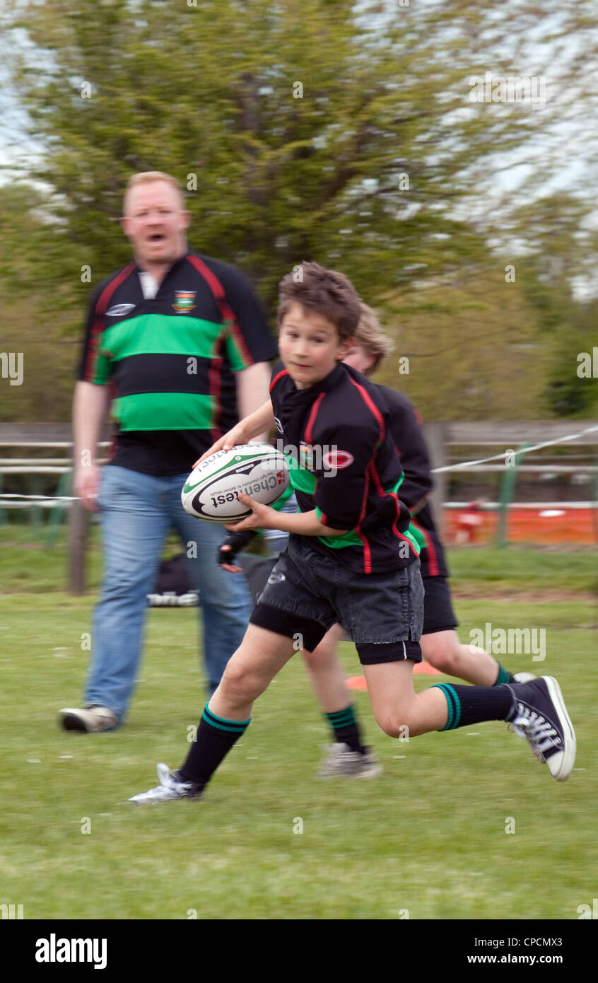 Rugby Junior - garçon exécutant avec la balle - motion blurred, Newmarket Suffolk Juniors Rugby Club UK Banque D'Images