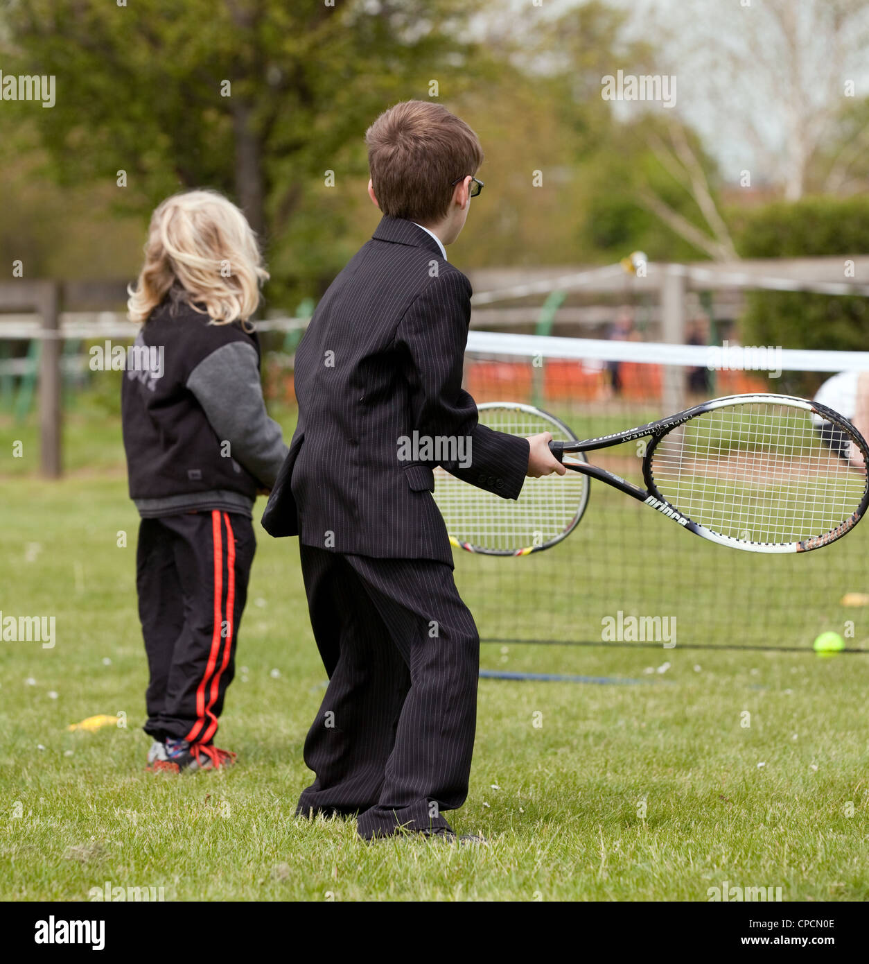 Deux jeunes enfants d'apprendre à jouer au tennis, vue arrière, Newmarket Suffolk UK Banque D'Images