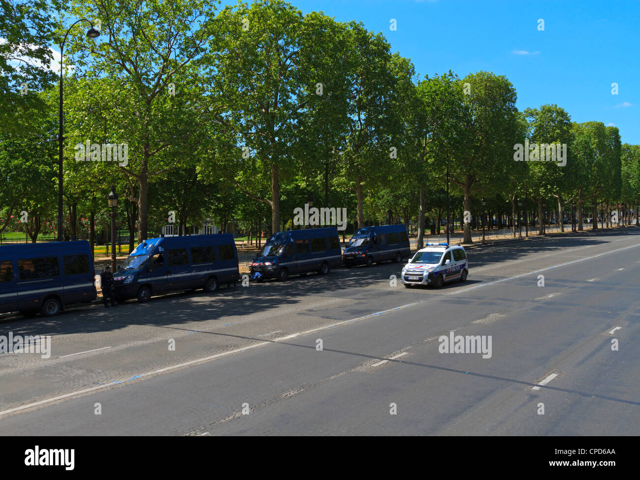 Cars de gendarmerie stationnées sur l'Avenue des Champs Elysées et une voiture de police passant, Paris Banque D'Images