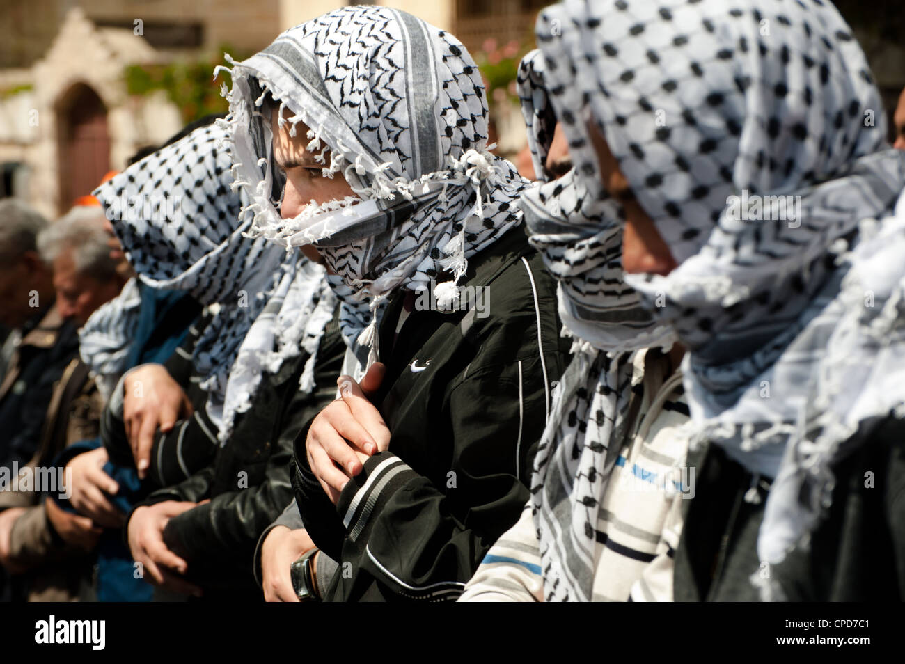 Les musulmans palestiniens portant des keffiyehs dire prière de midi lors des démonstrations de jour près de Bethléem checkpoint. Banque D'Images