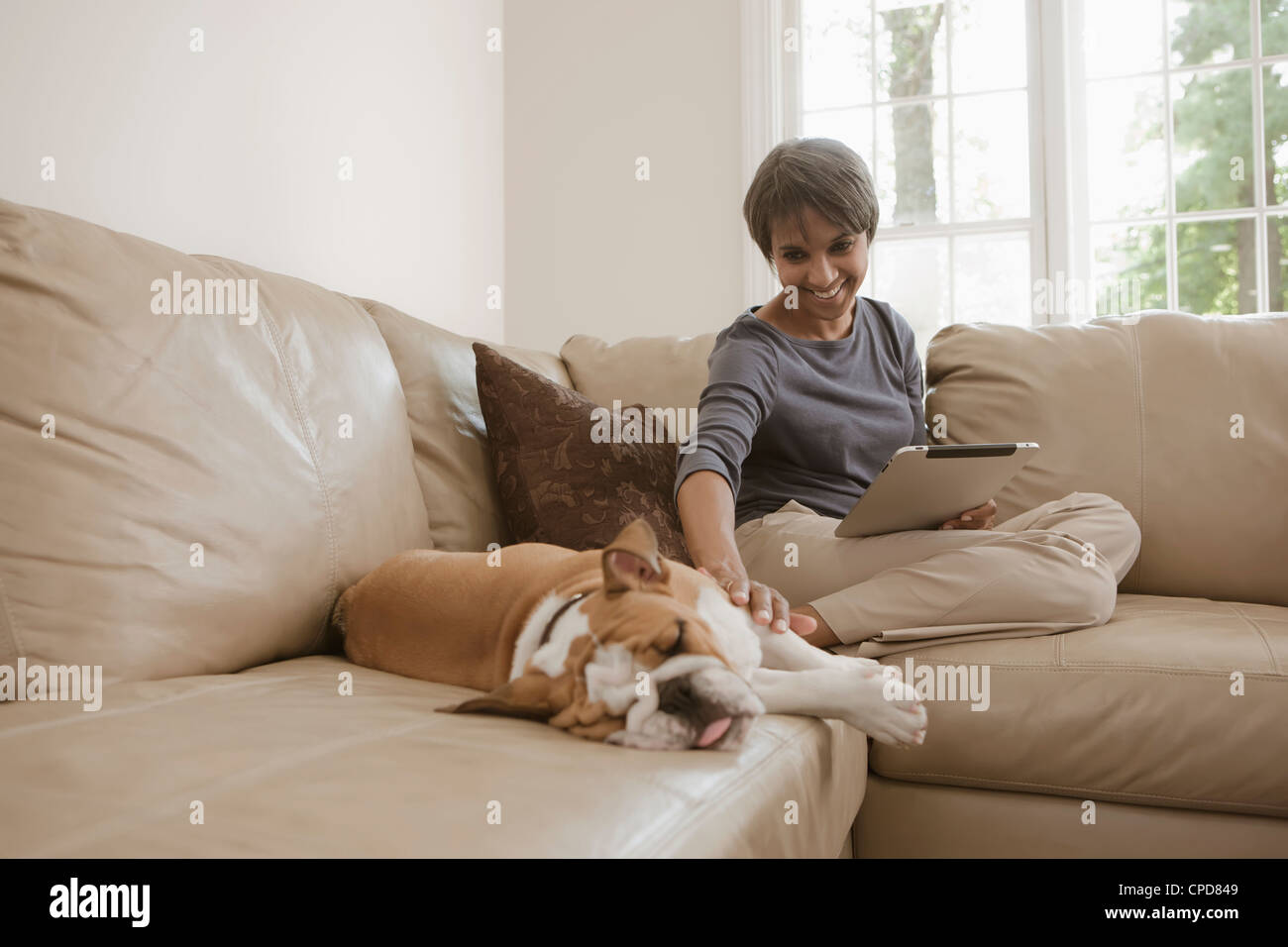 Native American Woman sitting on sofa avec bulldog Anglais Banque D'Images