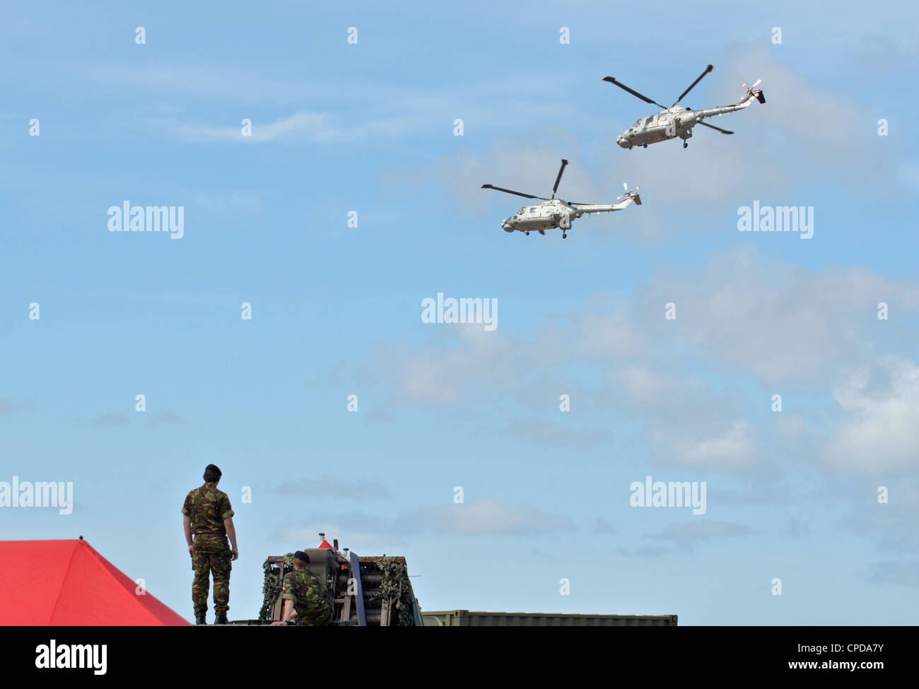 Soldats britanniques regarder comme deux chats noirs de la Marine royale des hélicoptères Lynx de voltige et effectuer des cascades mi le 23 juillet 2011. Banque D'Images