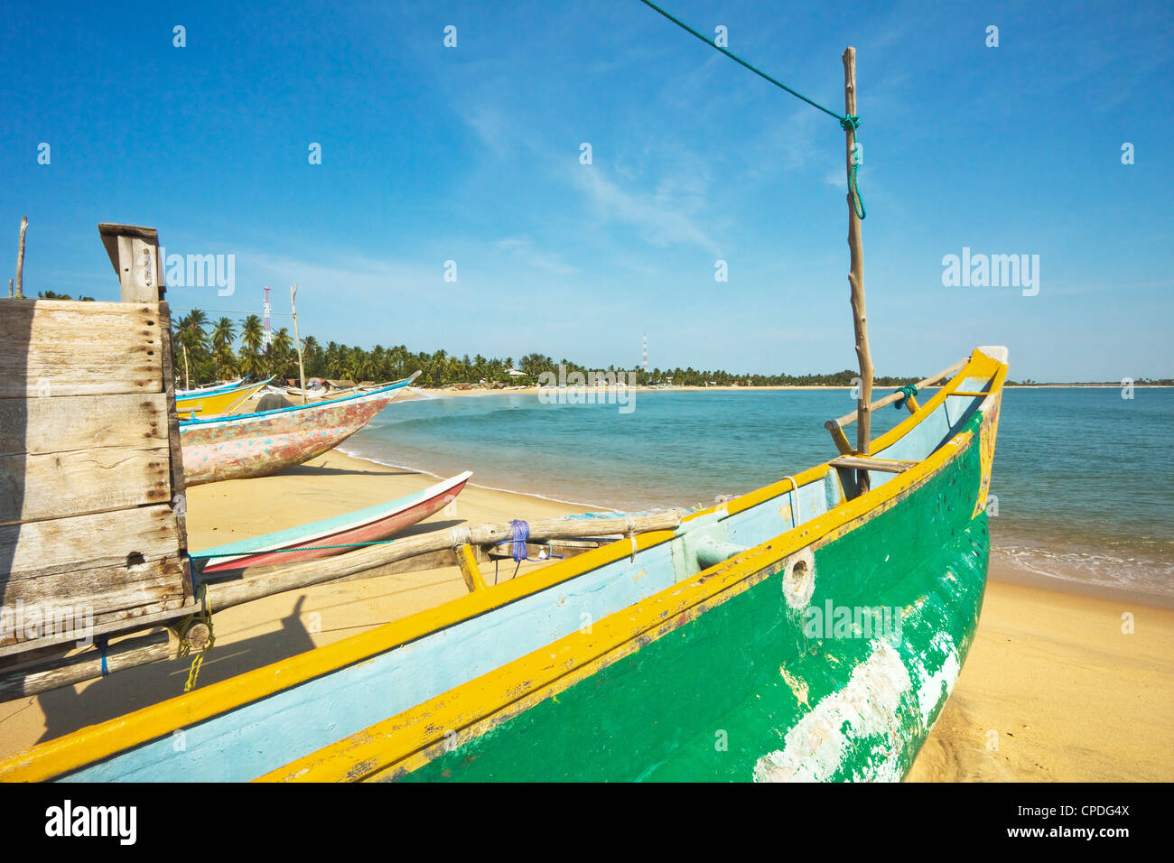 Outrigger bateaux de pêche sur la plage de surf populaire, durement touchée par le tsunami de 2004, d'Arugam Bay, province de l'Est, Asie, Sri Lanka Banque D'Images