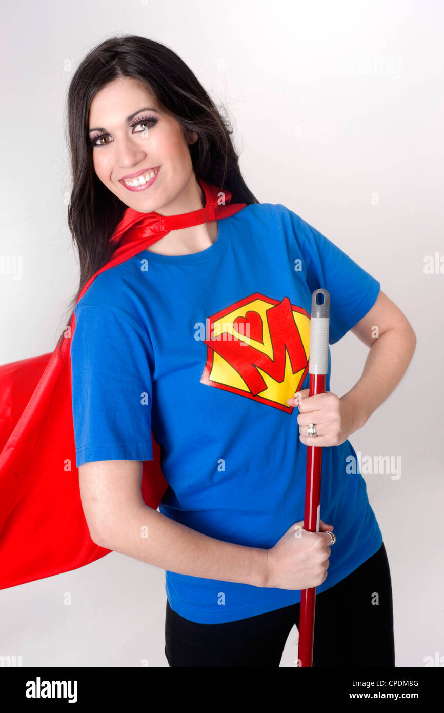 Femme porte un t-shirt de style super-héros et le cap holding a broom Banque D'Images