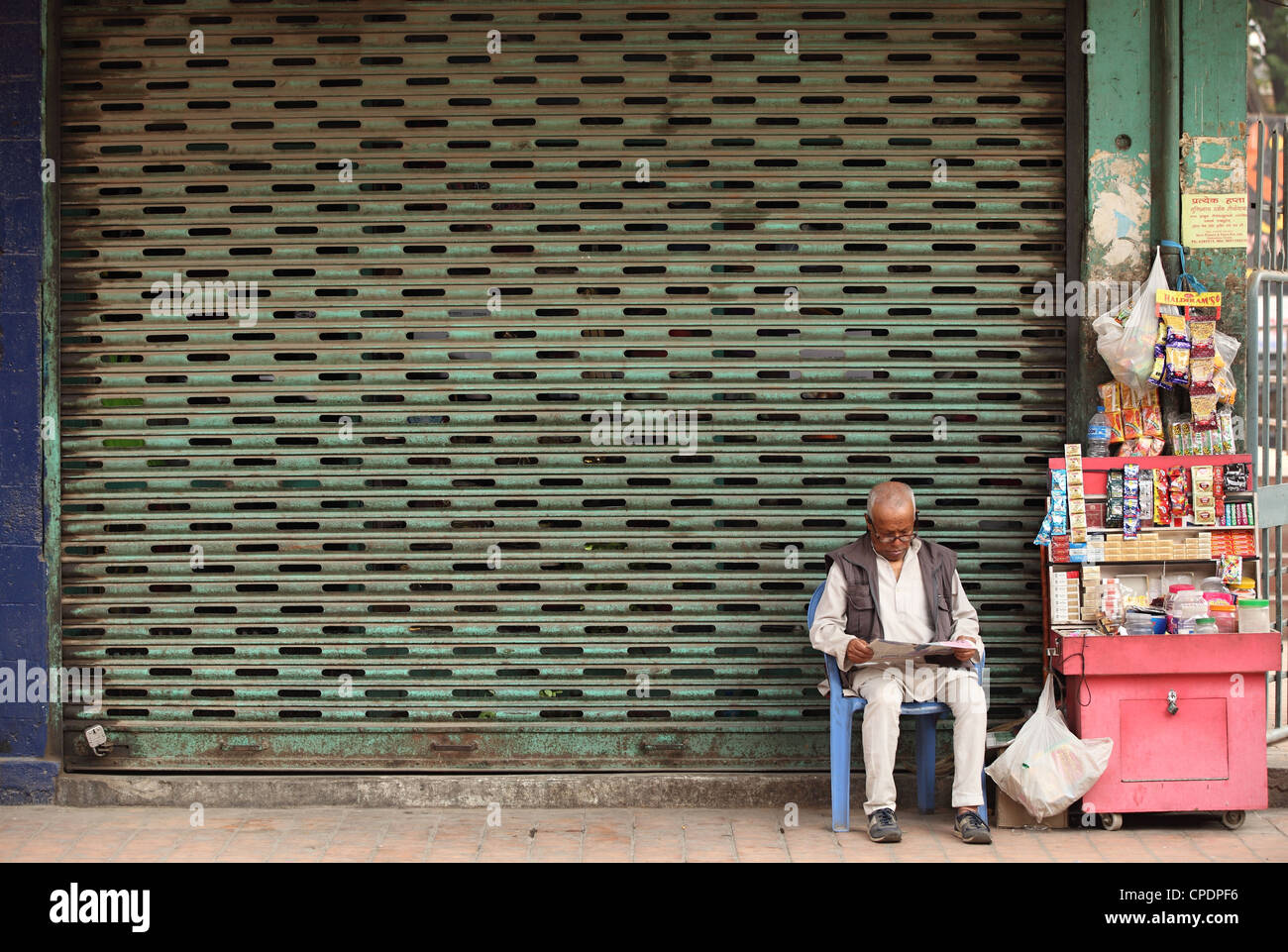 Vendeur de rue en face de l'atelier fermé Katmandou Népal Banque D'Images