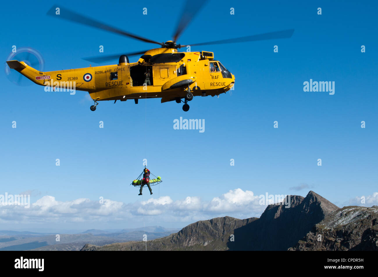 Hélicoptère Sea King de la RAF Valley, assistés par des équipes de sauvetage en montagne sauvetage blessé walker dans le Snowdonia Banque D'Images