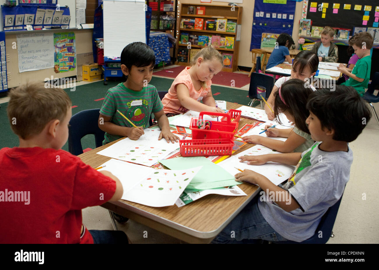 Groupe multi-ethnique des élèves de maternelle au travail d'une grande table dans la classe de l'école élémentaire publique du Texas Banque D'Images