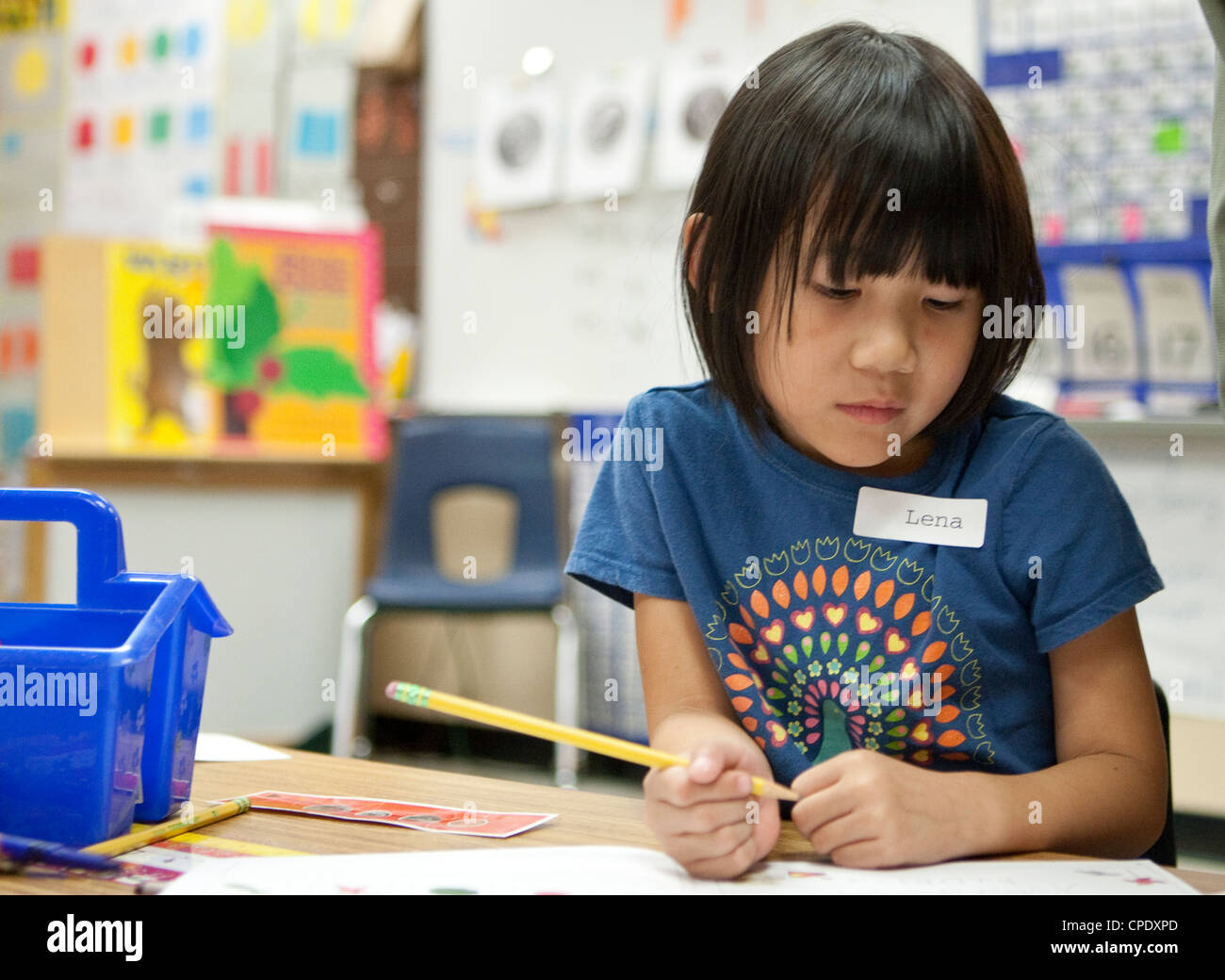 Des travaux d'étudiants américains d'origine maternelle des femmes à son bureau pendant la classe à l'école élémentaire publique du Texas Banque D'Images