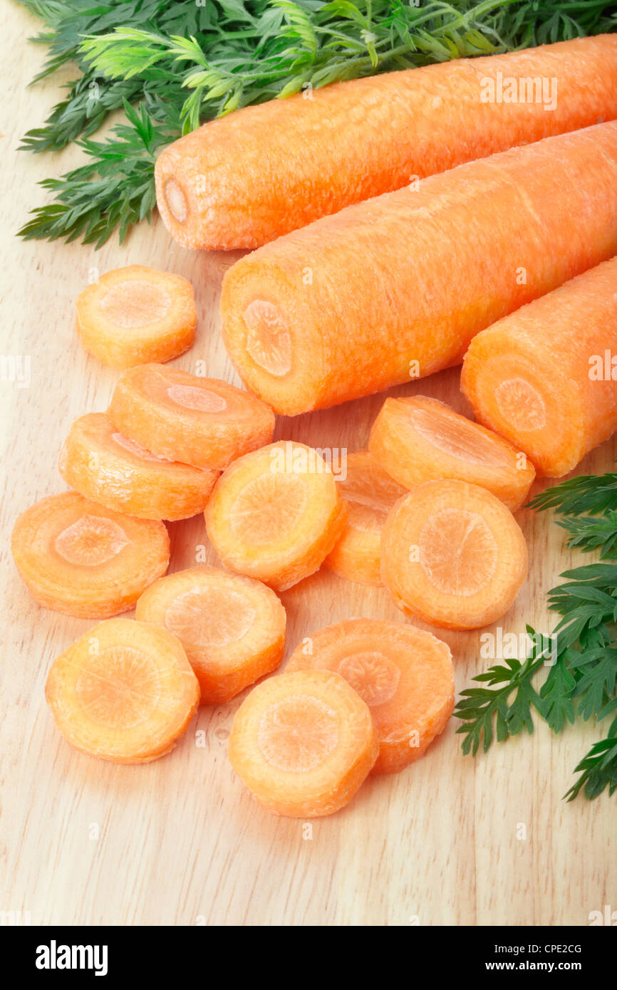 Les carottes en tranches sur une planche à découper Banque D'Images