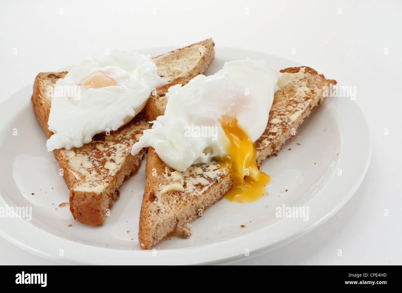 Deux œufs pochés sur toast avec écoulement nasal jaune doré Banque D'Images