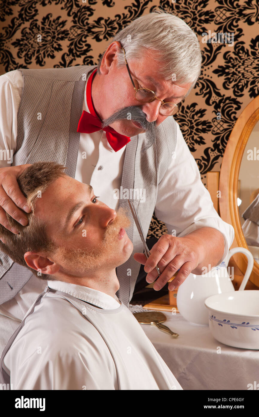 Coiffure couper la moustache d'un client dans une antique victorian barbershop Banque D'Images