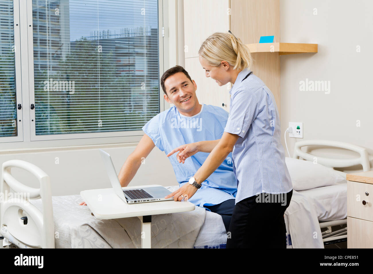 Nurse and patient in hospital ward Banque D'Images