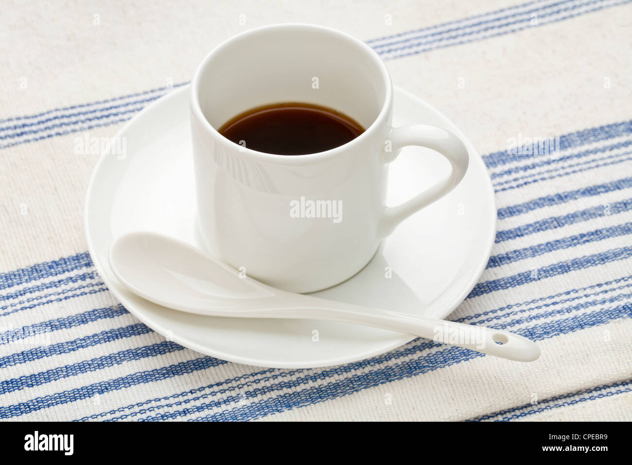 La porcelaine blanche tasse de café espresso avec une cuillère en céramique contre coton, nappe Banque D'Images