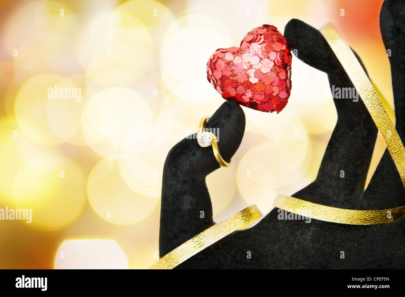 M'épouser ! - Donner la bague de fiançailles en diamants et mousseux rouge coeur comme symbole de l'amour. Plus de feux de flou artistique avec de la place pour Banque D'Images