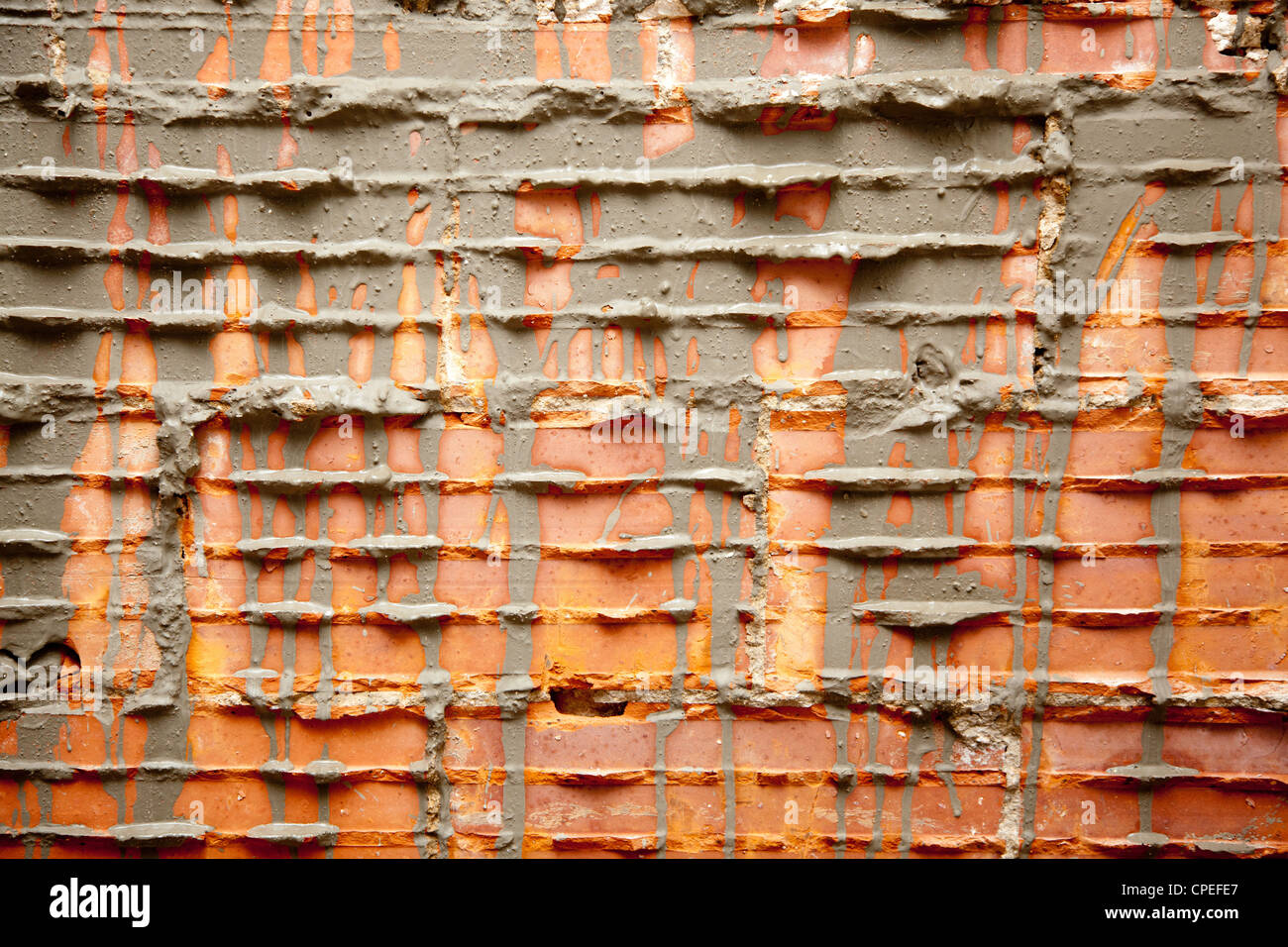 Casse briques dans la construction de murs en brickwall avec coulis de ciment Banque D'Images