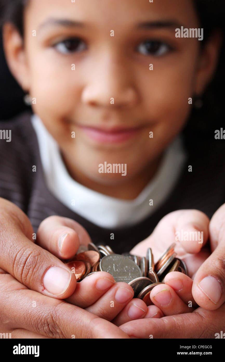 Pile de pièces assis dans la main d'un enfant Banque D'Images