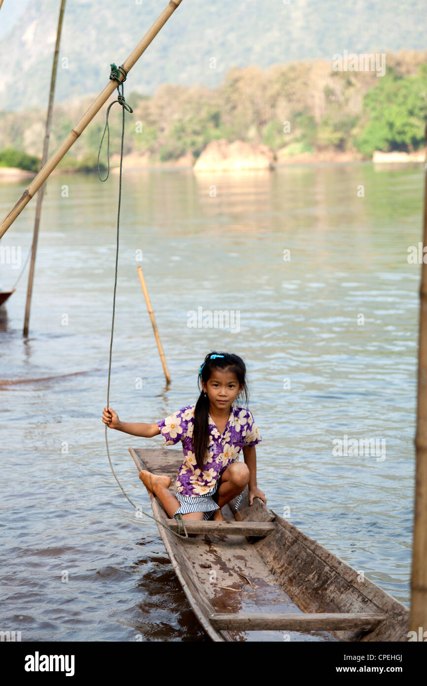 Un peu jeune fille laotienne dans une embarcation sur la rivière d'uo (Laos). Filette Laotienne posant dans une barque sur la rivière ou. Banque D'Images