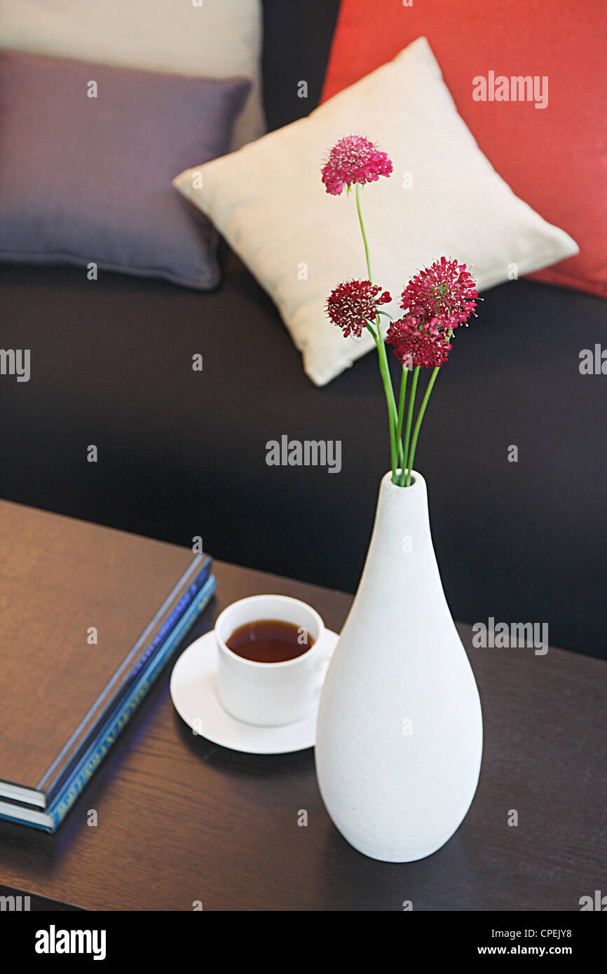 Plateau sur une table basse avec arrangement floral et Livres Banque D'Images