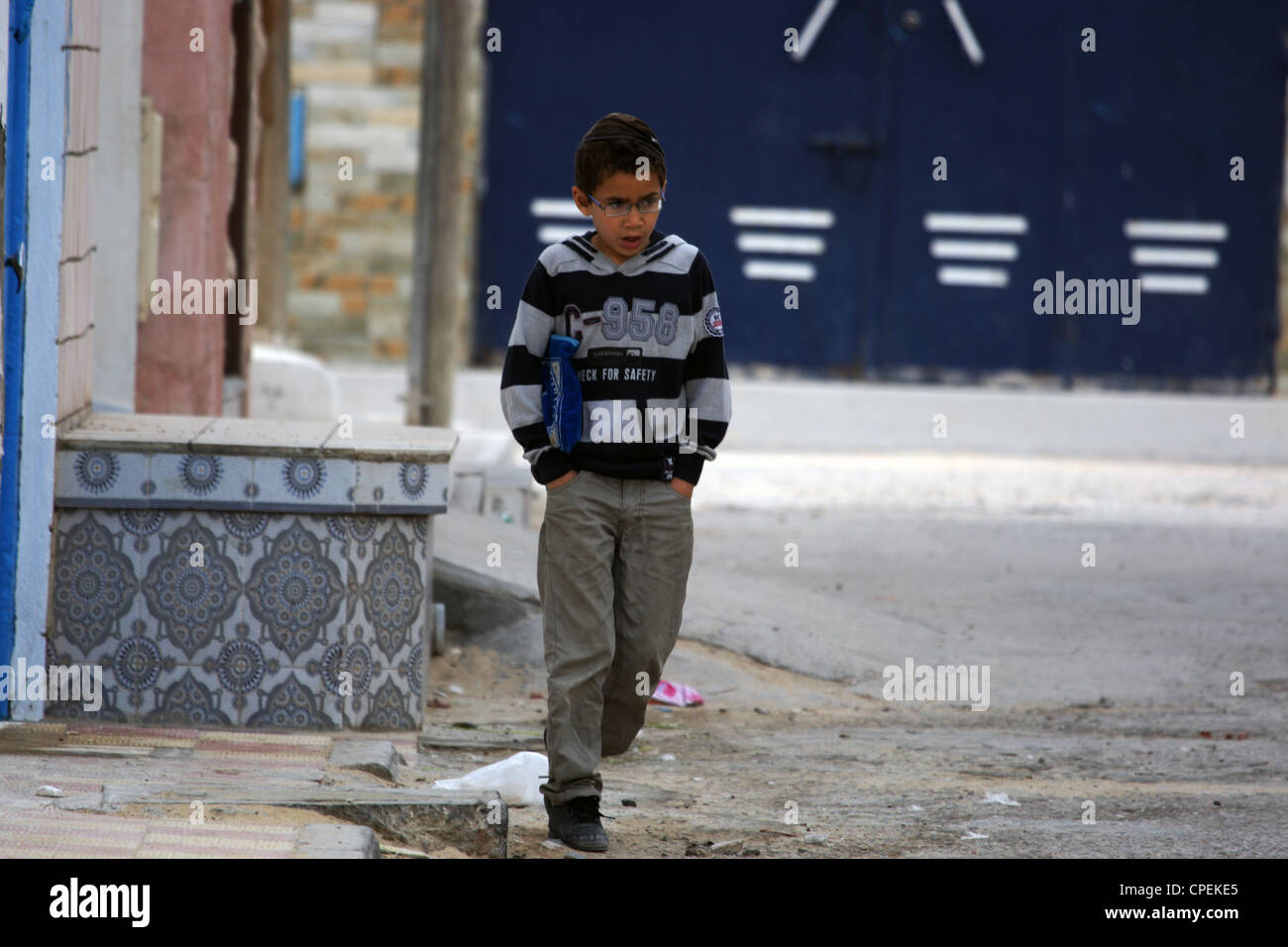 Un jeune écolier juif bâillements alors qu'il allait à l'école, Djerba, Tunisie Banque D'Images