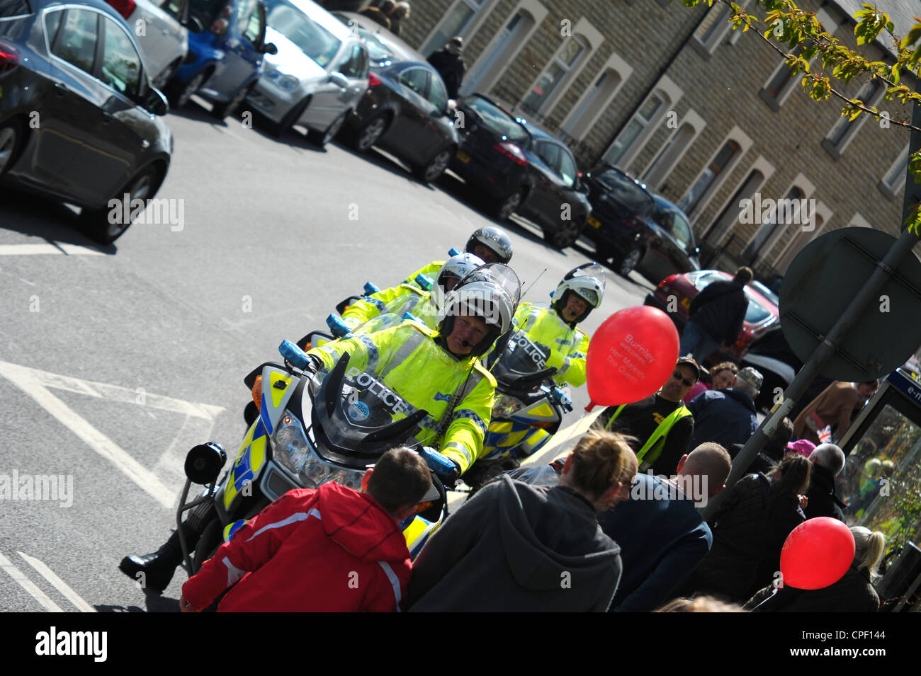 Les motocyclistes de la police en attente à une jonction pour diriger le trafic lorsque la reine d'Angleterre est passé dans son cortège royal. Banque D'Images