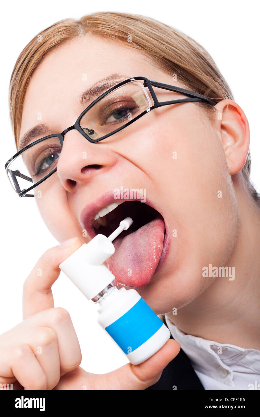 Femme avec mal de gorge à l'aide de spray oral, isolé sur fond blanc. Banque D'Images