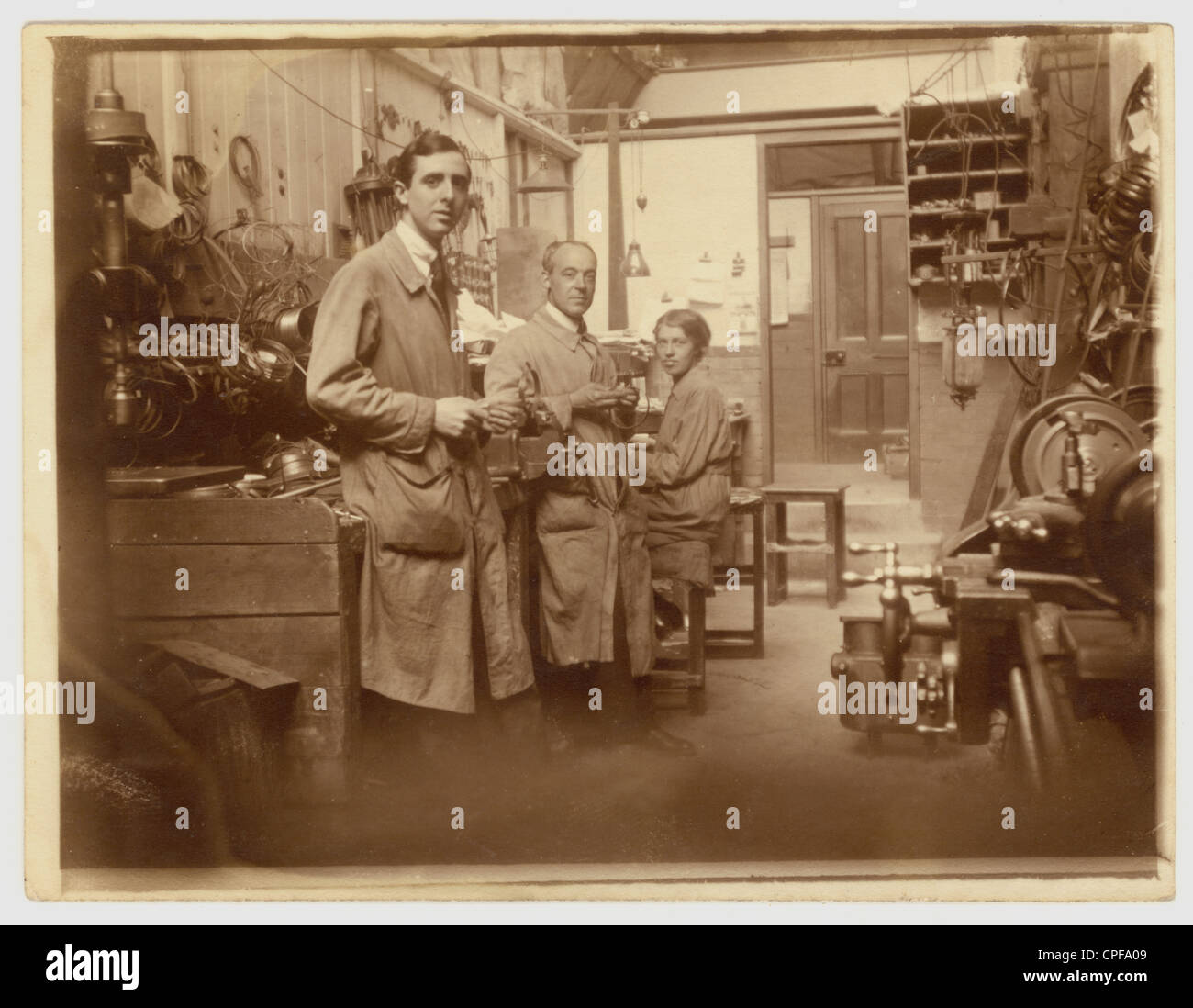 Photo originale d'hommes et d'une femme travaillant dans un atelier d'ingénierie, le groupe regroupe des portraits professionnels. Peut-être faire des réparations, début des années 1900, victorienne, édouardien Royaume-Uni Banque D'Images