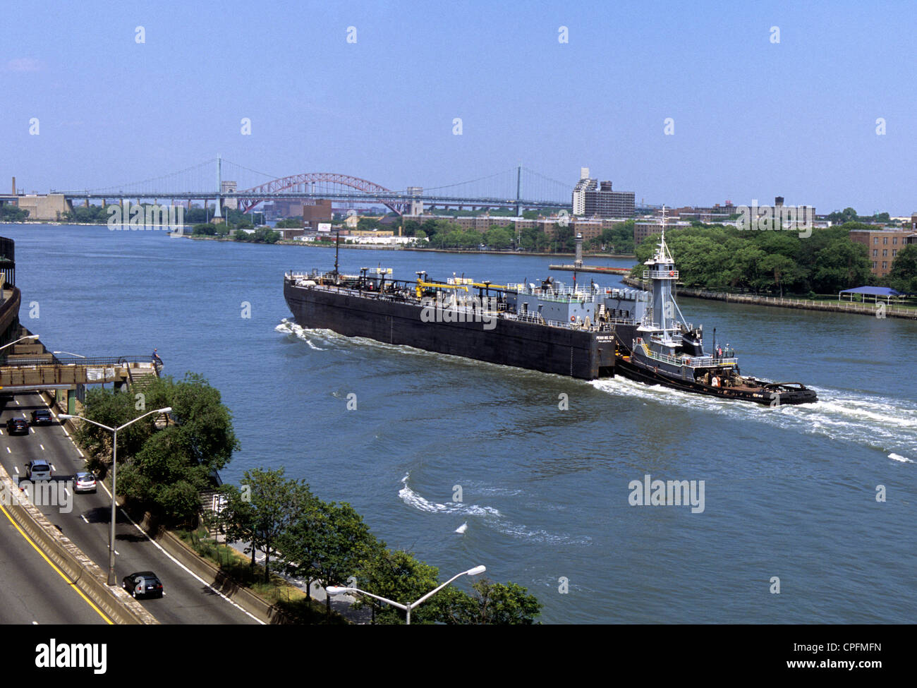 Remorqueurs et chalands en pétrole, ou barge de pétroliers, sur la rivière East, New York, FDR Drive. Pont Robert F Kennedy Pont Hell Gate Bridge en arrière-plan. ÉTATS-UNIS Banque D'Images