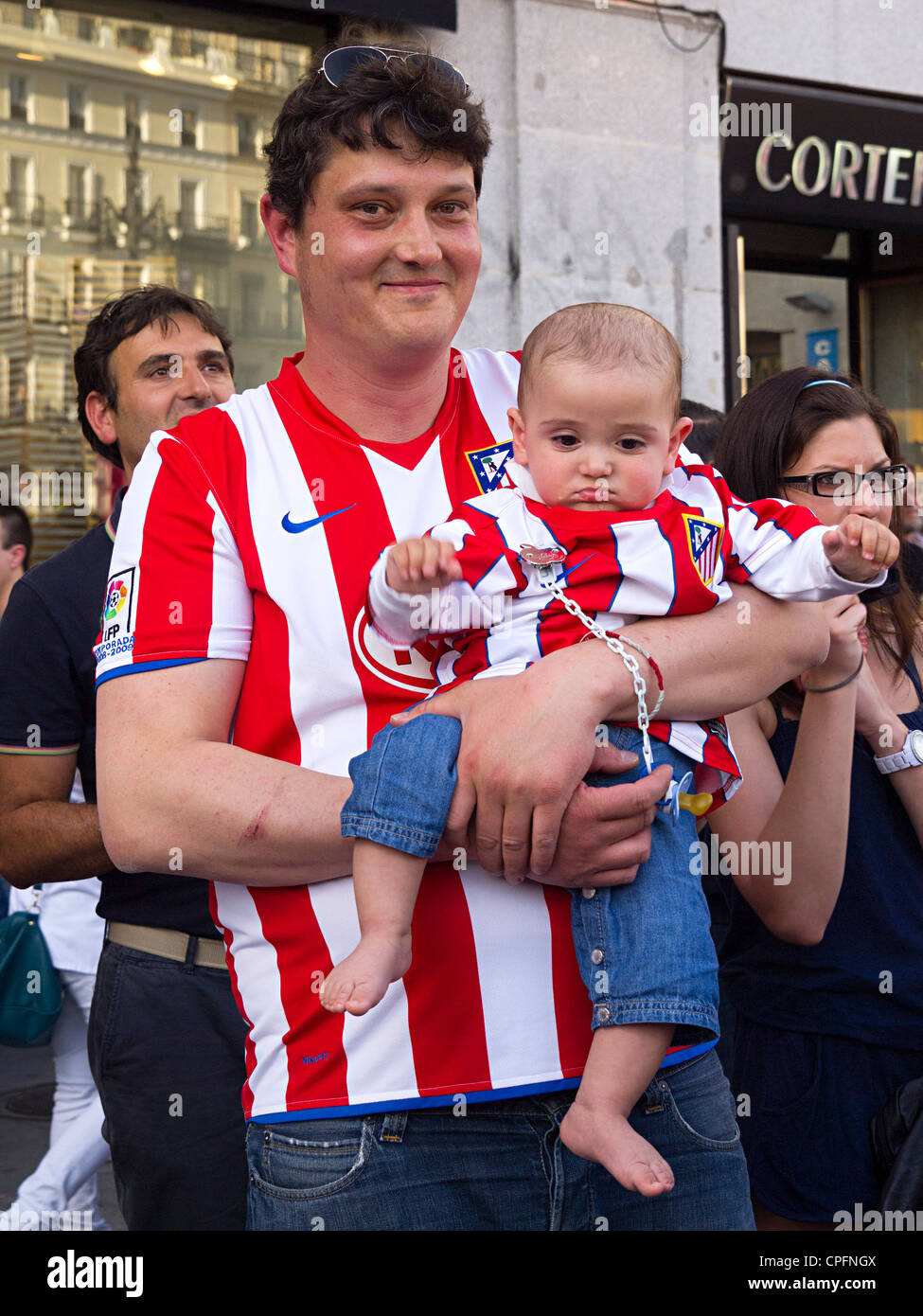 L'Atletico Madrid fan holding baby avec team jersey Banque D'Images