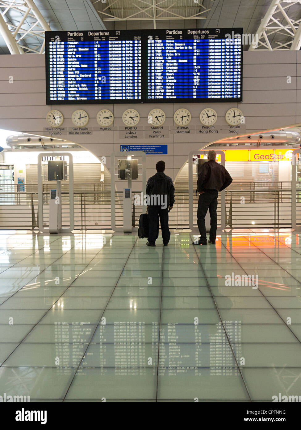 Les gens observant le calendrier d'administration à l'aérogare de l'aéroport Sá Carneiro de Porto, Portugal Banque D'Images