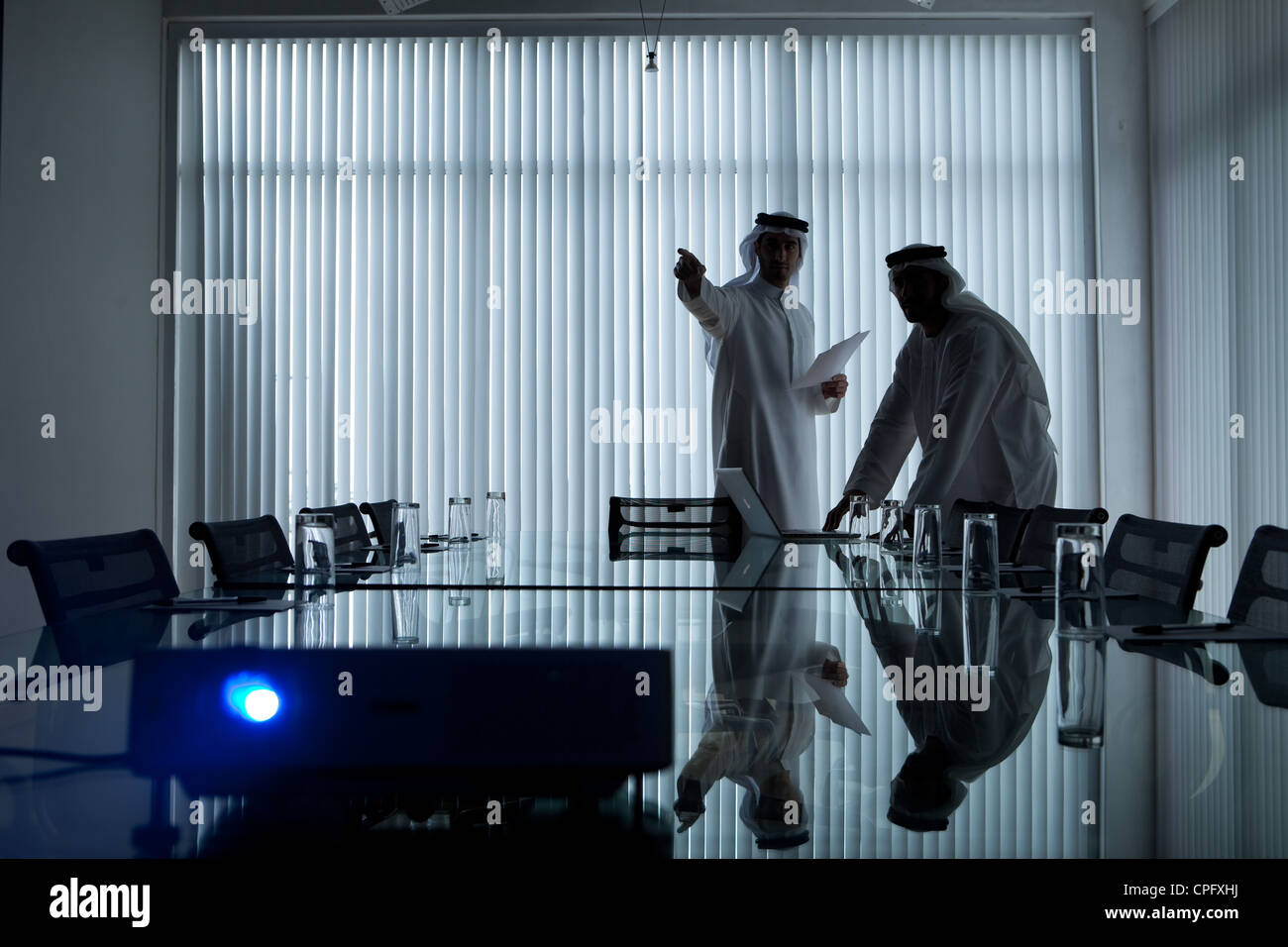 Deux hommes d'affaires arabes réunion dans une salle de conférence, l'homme, pointant sur l'exposé. Banque D'Images