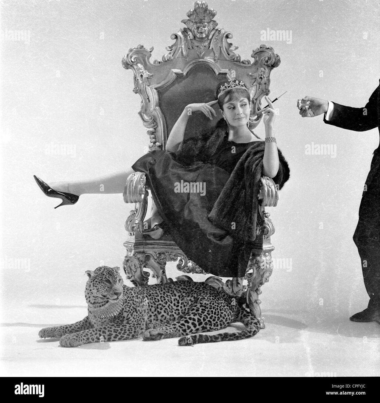 Se référant toujours à partir des années 60. Femme sur un trône avec une cigarette en porte-cigarette étant attendu sur avec un léopard à ses pieds. Banque D'Images