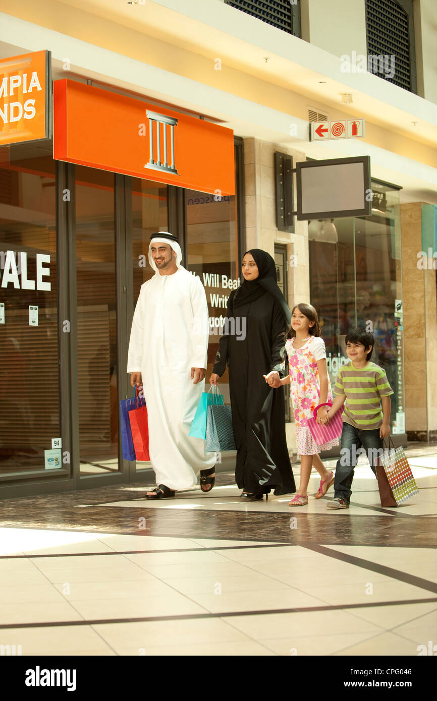 Famille arabe tenant la main tout en marchant dans le centre commercial. Banque D'Images