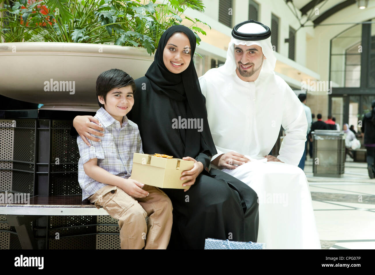 Portrait de famille arabe avec des cadeaux assis au centre d'achat. Banque D'Images