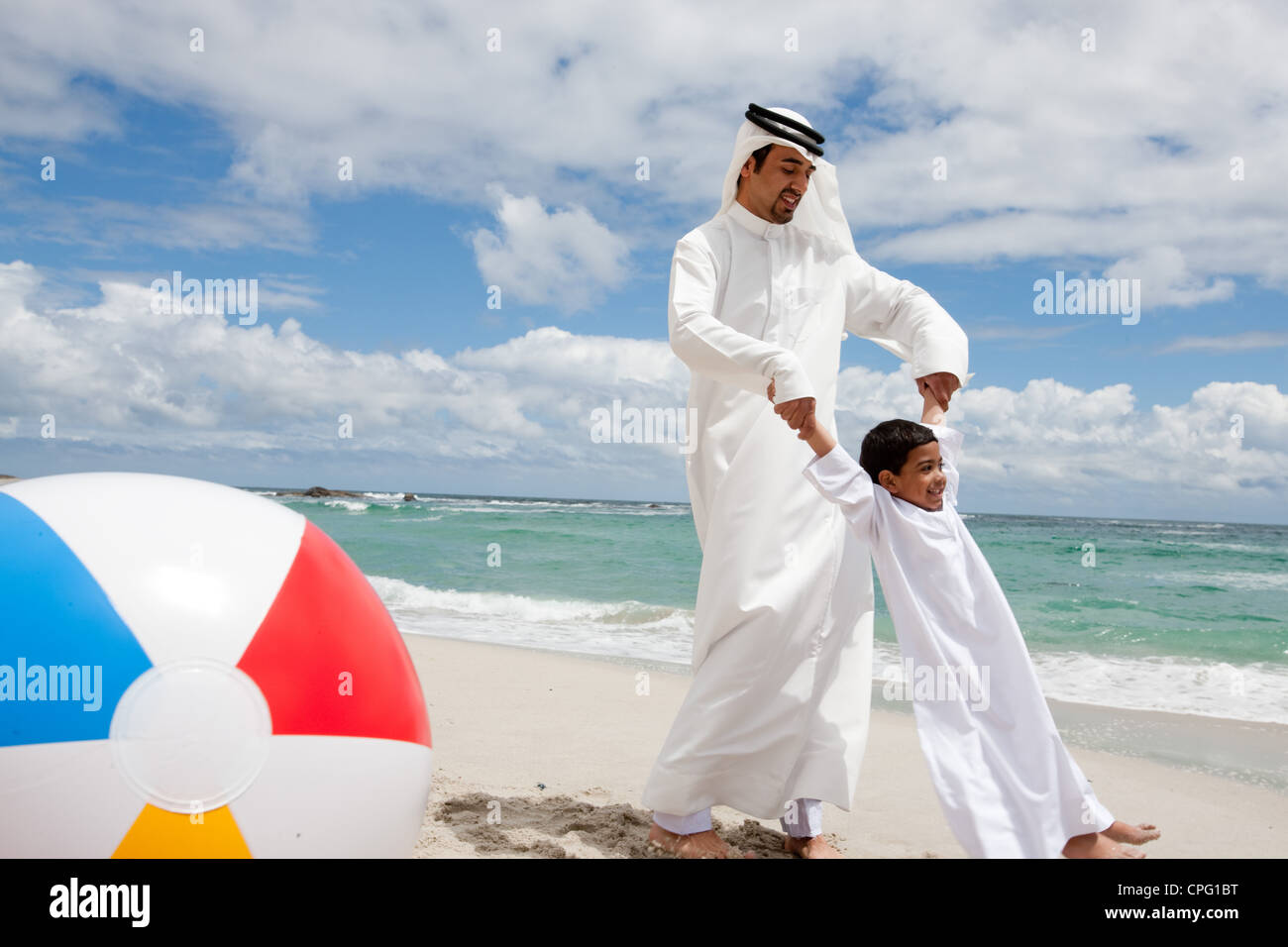 Père arabe tourner autour de son fils à la plage. Banque D'Images