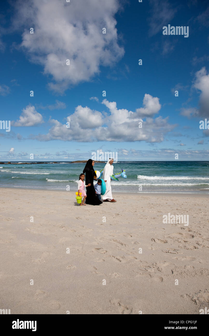Famille arabe tenant la main en marchant sur la plage. Banque D'Images