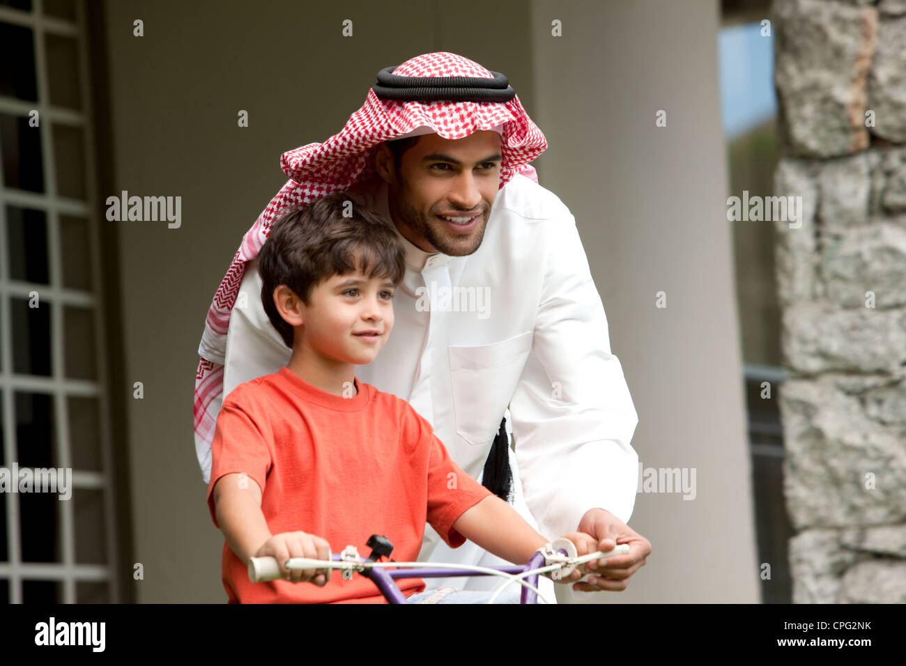 L'enseignement arabe père son fils comment monter à vélo. Banque D'Images