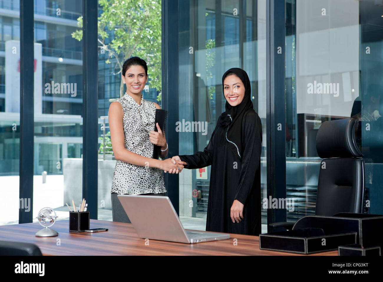 Two businesswomen shaking hands in office. Banque D'Images