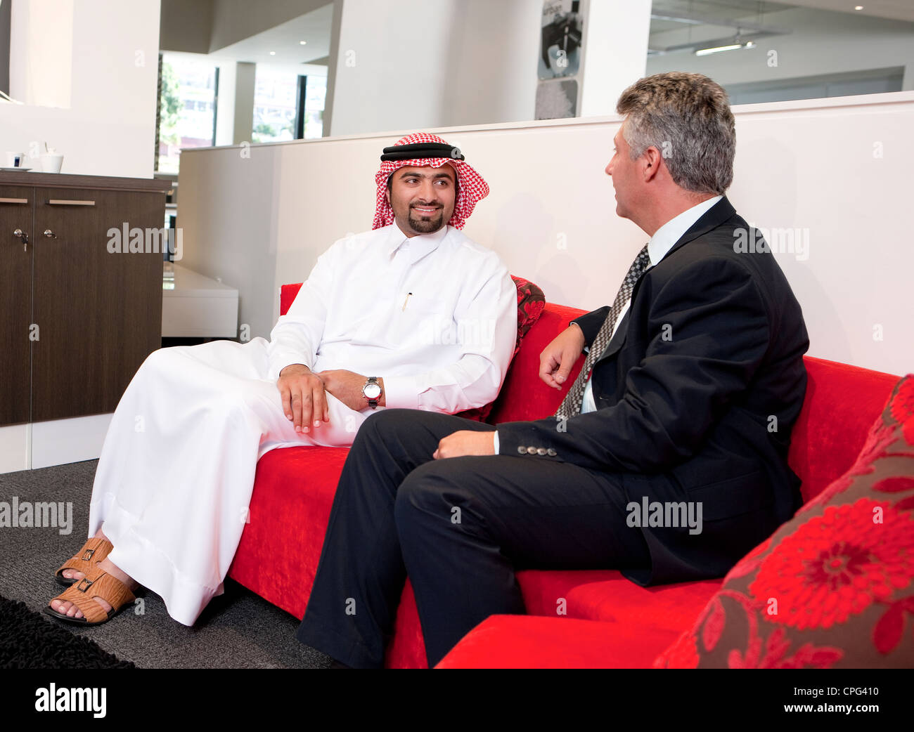 Deux businessmen talking on sofa in office. Banque D'Images