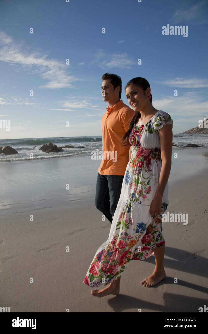 Couple holding hands and walking on beach. Banque D'Images
