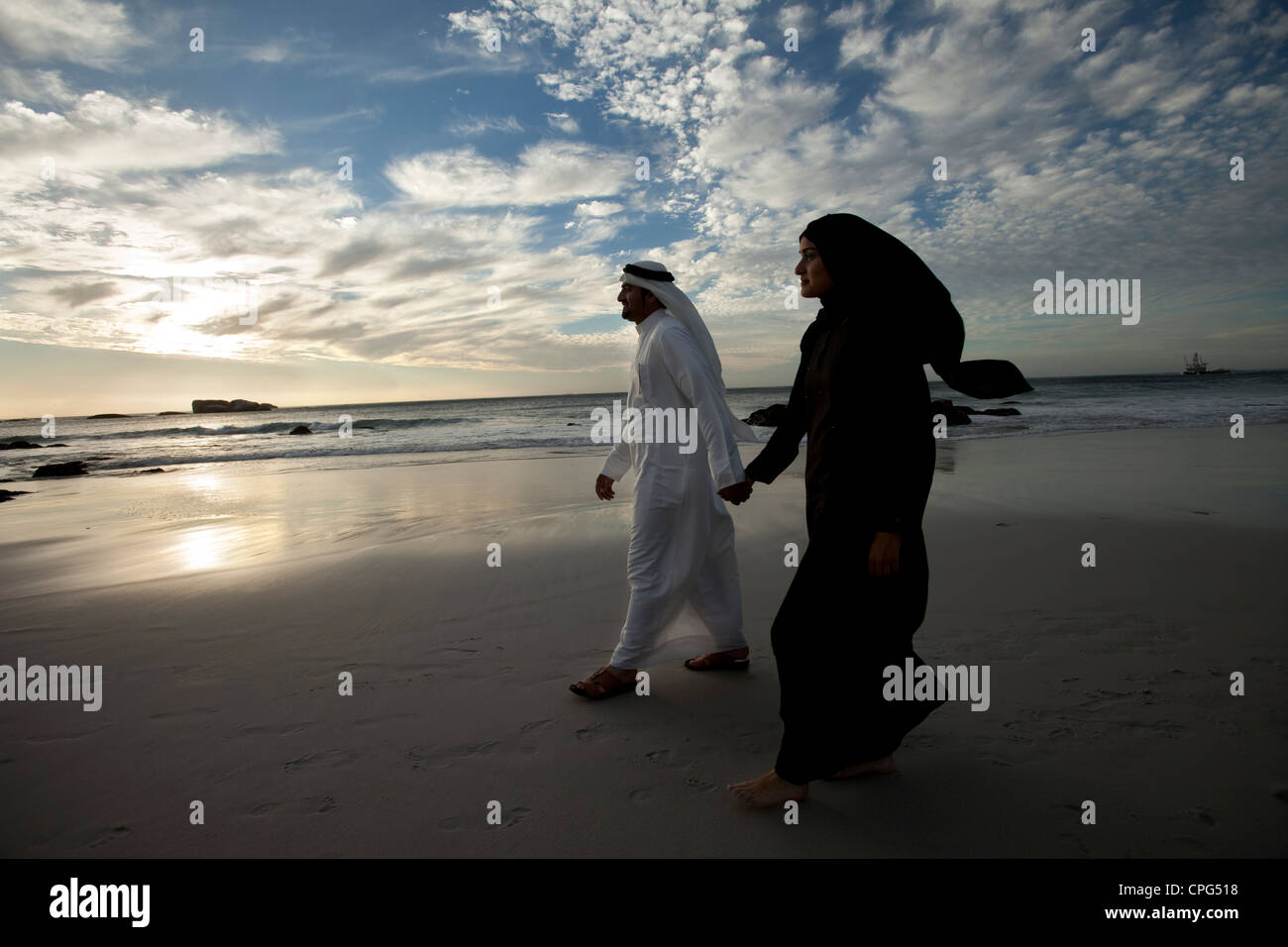 Couple arabe par la plage, se tenant la main. Banque D'Images