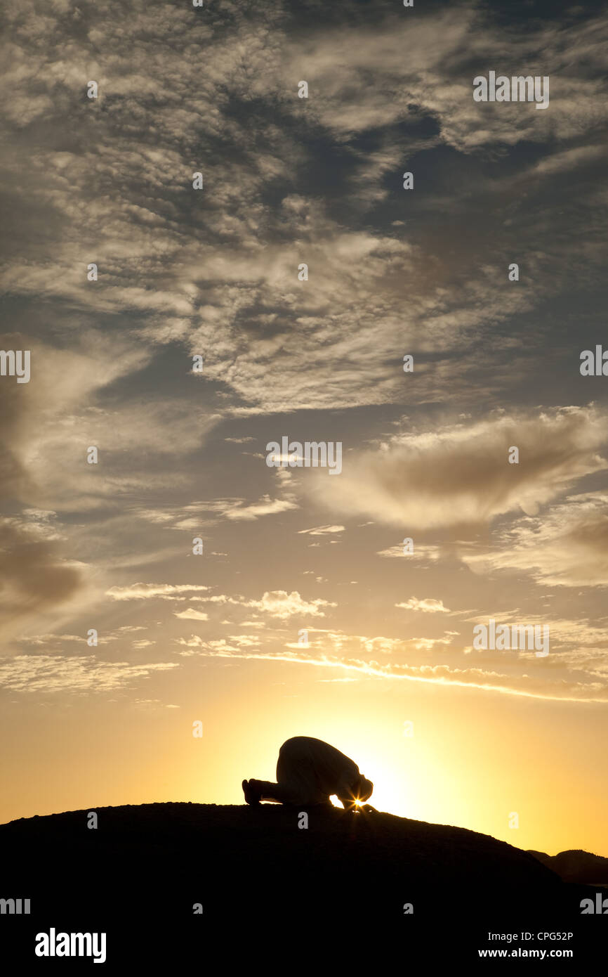 L'homme arabe prier sur le haut de la roche. Banque D'Images