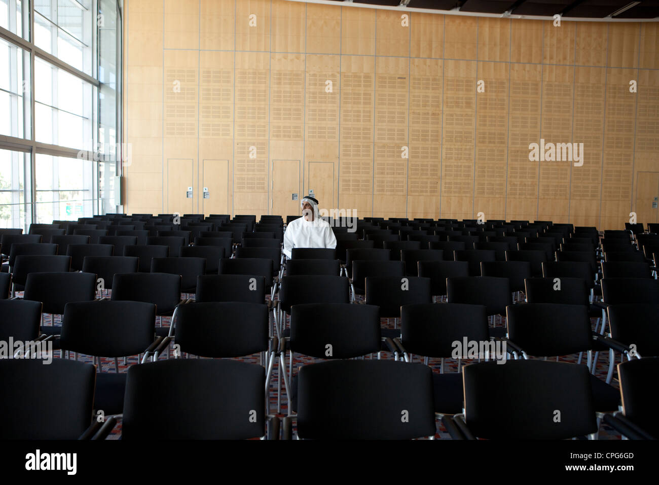 Arab businessman sitting in empty auditorium. Banque D'Images