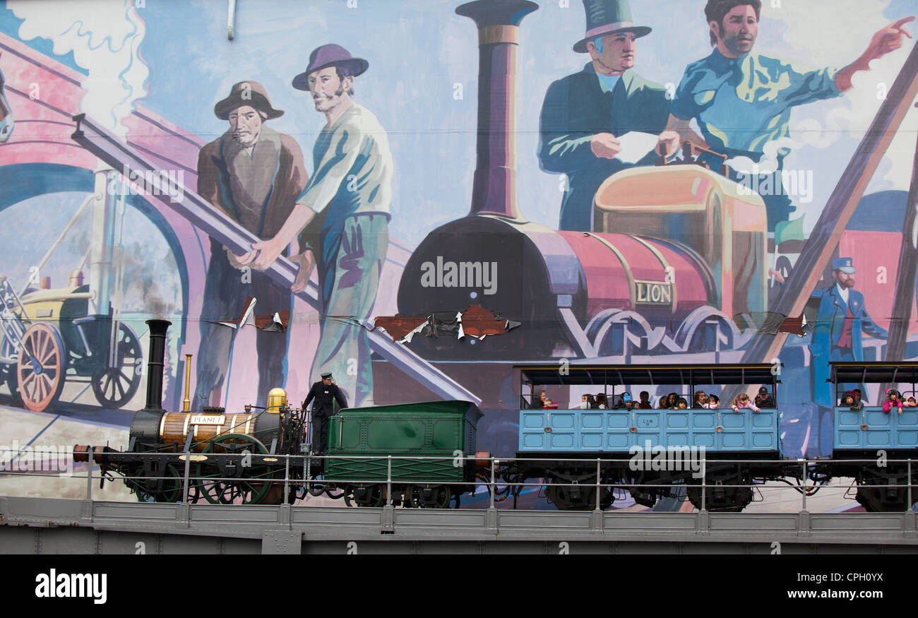 Réplique du train à vapeur de la planète au Musée des sciences et de l'industrie Manchester UK passant grande fresque avec Lion Stephenson's Rocket Banque D'Images